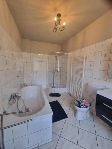 a white bathroom with a tub and a toilet at Landhaus Bia in Burig