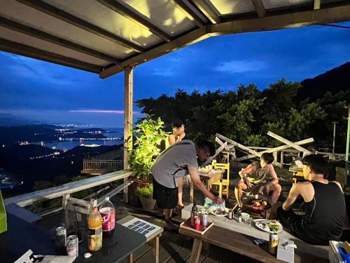 a group of people sitting on a deck at night at 九份山嶼海 in Jiufen