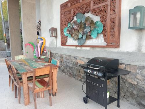 a patio with a table and a grill and a table and chairs at Liri Villa - 4 BRs - Ocean, Valley view in Temukus