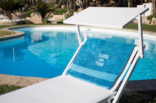 a blue towel sitting on a chair next to a swimming pool at Suite Nuragus in Porto Rotondo