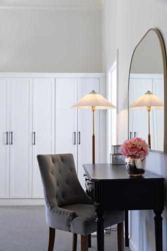 a room with a table and a chair and a mirror at Palm House Boutique Hotel and Spa in Cape Town