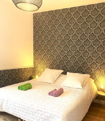 a bedroom with a bed with two slippers on it at CH1- MANOIR DU MOULINIER - Campagne - Calme - Petit-déj inclus - Table d'hôte sur réservation - Parking gratuit in La Limouzinière