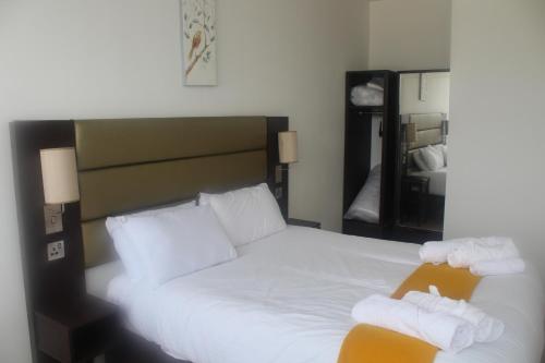 a bedroom with a large white bed with two towels at Flat 414 One bedroom apartment in Birmingham