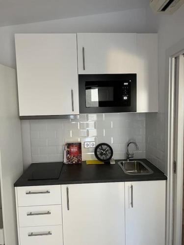 a kitchen with a sink and a microwave at Acogedor piso independiente Valldoreix in Sant Cugat del Vallès
