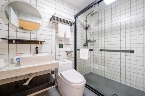 un bagno con un water, un lavandino e uno specchio di LIU YUAN Amoy Smart Hotel 厦门留苑智能酒店 a Xiamen