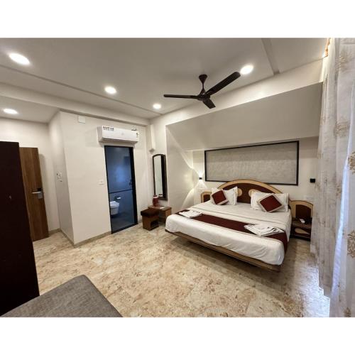 a bedroom with a bed and a ceiling fan at Hotel Always Welcome by SAH in Mount Ābu