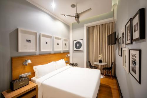a bedroom with a large white bed and a table at Browns Downtown Hotel in Lisbon