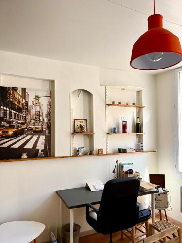 un bureau avec un bureau et une lampe rouge dans l'établissement Studio lumineux quartier Baille, à Marseille