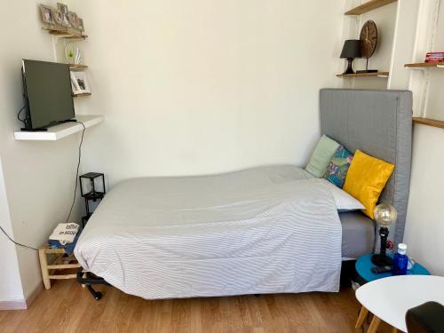 Ce lit se trouve dans une petite chambre dotée d'un mur blanc. dans l'établissement Studio lumineux quartier Baille, à Marseille