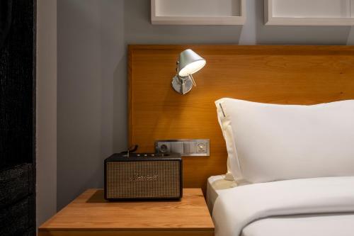 a bedroom with a bed with a clock and a lamp at Browns Downtown Hotel in Lisbon