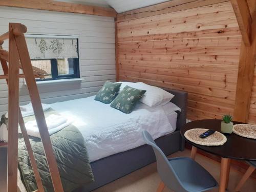 a bedroom with a bed and a table and a chair at The Barn Mid Bedfordshire in Haynes