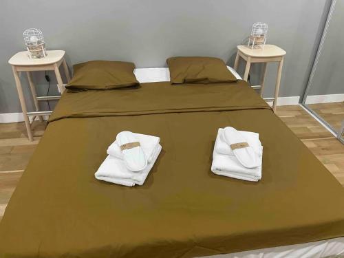 - un lit avec des serviettes et 2 tables dans l'établissement Duplex au Sentier secret au cœur de Paris, à Paris