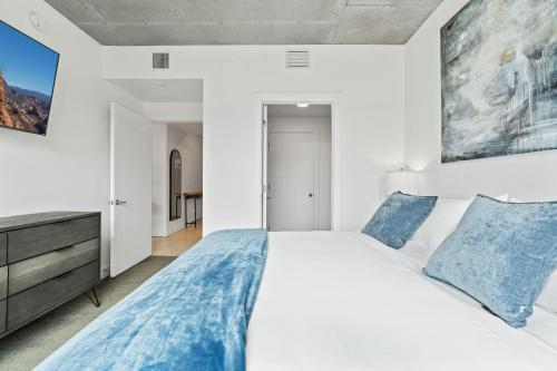 a bedroom with a large white bed with blue pillows at 2bd 2ba Best style and location Pool spa gym pkg! in American Towers Condominium