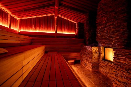 a sauna with a wooden floor and a brick wall at Hotel & Wellness Zuiver in Amsterdam