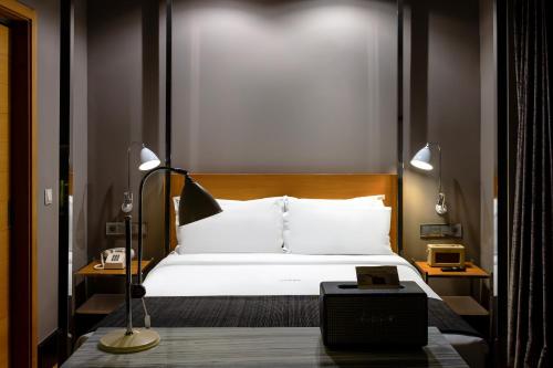 a bedroom with a white bed and a lamp at Browns Downtown Hotel in Lisbon