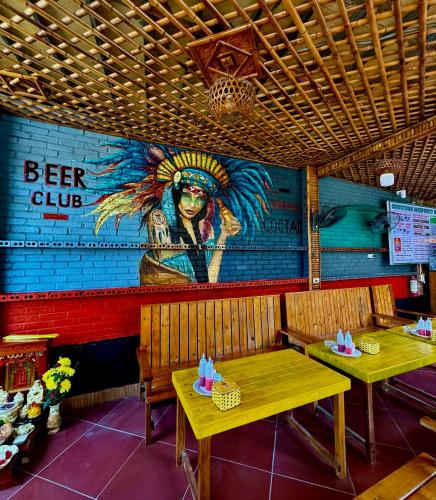 un ristorante con due tavoli e un murale sul muro di Downtown Backpacker Hostel a Ninh Binh