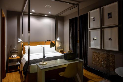 a bedroom with a bed and a desk with a lamp at Browns Downtown Hotel in Lisbon