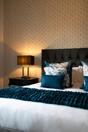 a bedroom with a large bed with a blue blanket at Palm House Boutique Hotel and Spa in Cape Town