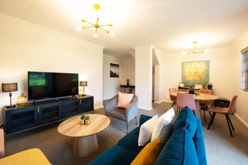 a living room with a blue couch and a tv at Palm House Boutique Hotel and Spa in Cape Town