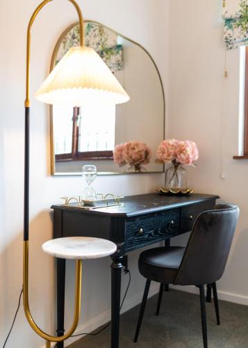 a desk with a lamp and a chair and a mirror at Palm House Boutique Hotel and Spa in Cape Town