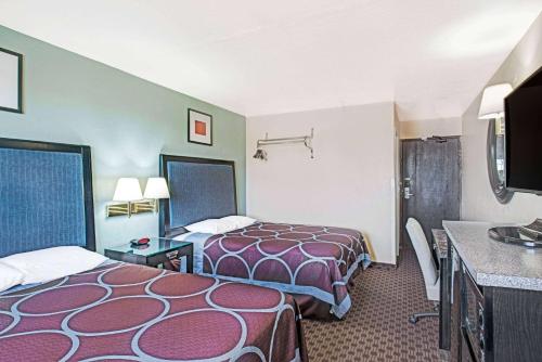 a hotel room with two beds and a flat screen tv at Super 8 by Wyndham Sacramento/Florin Rd in Sacramento