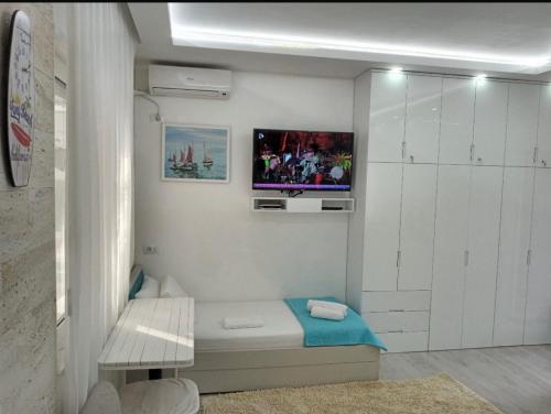 ein Wohnzimmer mit einem Fernseher an der Wand in der Unterkunft Reana Apartament Dhermi beach in Dhërmi