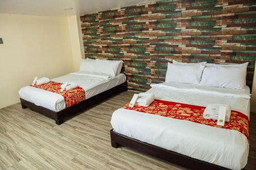 a hotel room with two beds and a brick wall at Balai La Niña Beach Resort in Aclan
