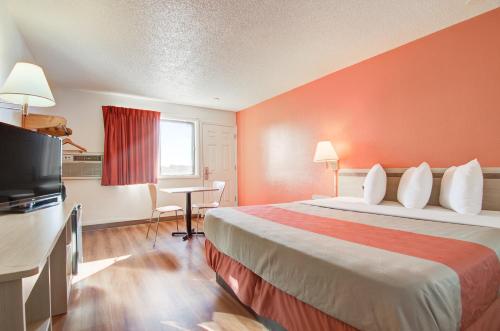 a hotel room with a bed and a flat screen tv at Motel 6-Colby, KS in Colby