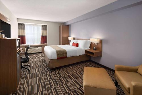 a hotel room with a bed and a desk at Microtel Inn & Suites by Wyndham Kirkland Lake in Kirkland Lake