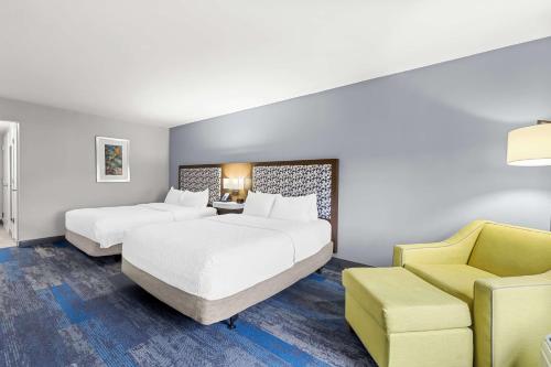 弗洛伦斯Hampton Inn Florence Midtown near University of North Alabama的酒店客房,设有两张床和一张黄色椅子