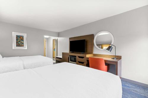 a hotel room with a bed and a desk with a mirror at Hampton Inn Florence Midtown near University of North Alabama in Florence