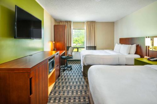 a hotel room with two beds and a flat screen tv at Comfort Inn in Midland