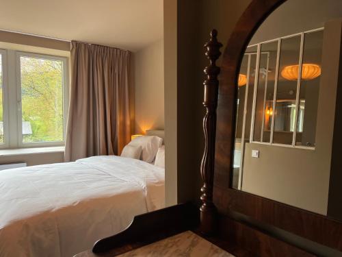 a bedroom with a bed and a mirror at Manoir Nestor - Chairière in Vresse-sur-Semois