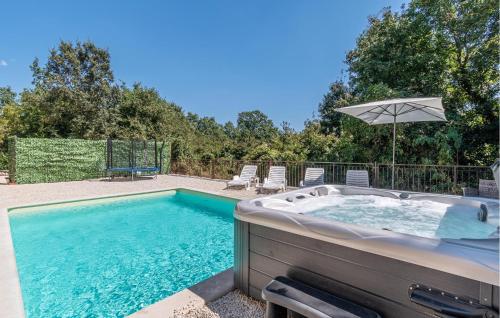 wanna z hydromasażem z krzesłami i parasolem na dziedzińcu w obiekcie Stunning Home In Trosti w mieście Rojnići