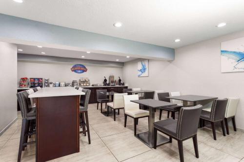 a restaurant with tables and chairs and a counter at Baymont by Wyndham Punta Gorda/Port Charlotte in Punta Gorda