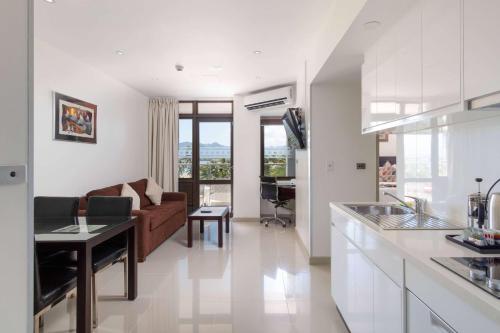 a kitchen and living room with a couch and a table at Ramada Suites by Wyndham Wailoaloa Beach Fiji in Nadi