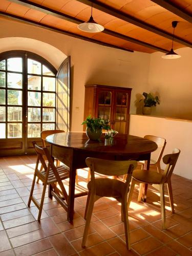 a dining room with a wooden table and chairs at Stone House in Wine Territory in Capmany