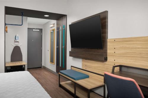 a hotel room with a bed and a flat screen tv at Tru By Hilton Jacksonville Airport in Jacksonville