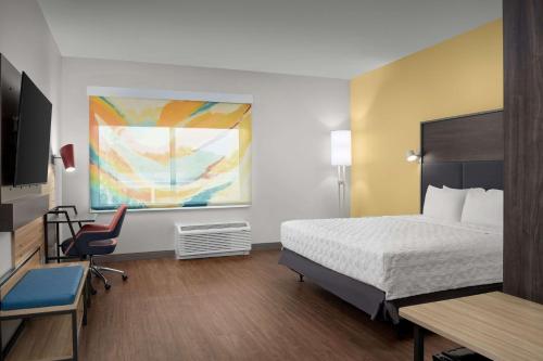 a hotel room with a bed and a desk at Tru By Hilton Jacksonville Airport in Jacksonville