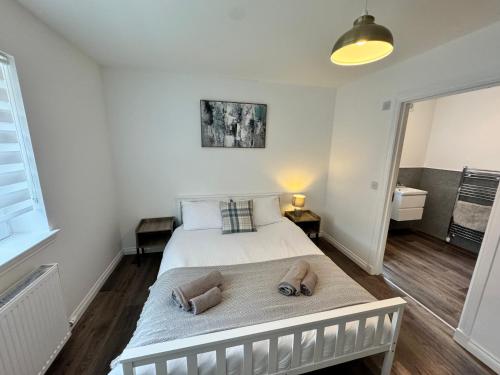 a bedroom with a bed with two towels on it at Inchcruin Apartment - Macaulay Letting in Bonhill
