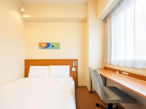 a hotel room with a bed and a desk and a window at Comfort Inn Toyokawa Inter in Toyokawa