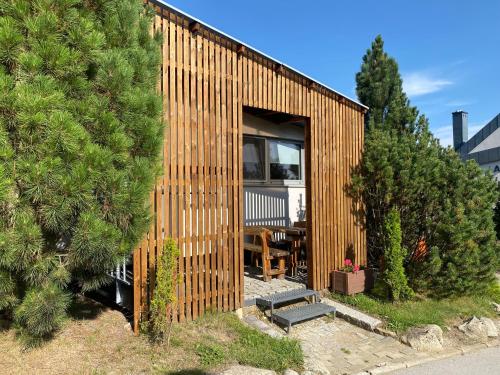 a small house with a wooden facade with trees at Mountain Villas Polana in Smokovce