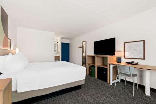 a hotel room with a bed and a desk at Spark By Hilton Hummelstown Hershey in Hummelstown