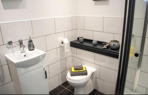 Un baño blanco con inodoro y lavabo. en Nottingham CityCentre-Studio-Free Parking-Wifi, en Nottingham