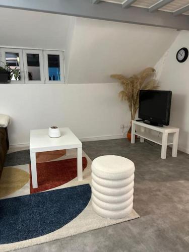 un salon blanc avec une table et une télévision dans l'établissement Bubble Sweet, à Montmorency