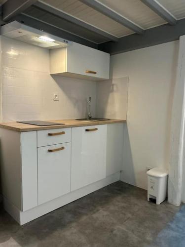 une cuisine avec des armoires blanches et un évier dans l'établissement Bubble Sweet, à Montmorency