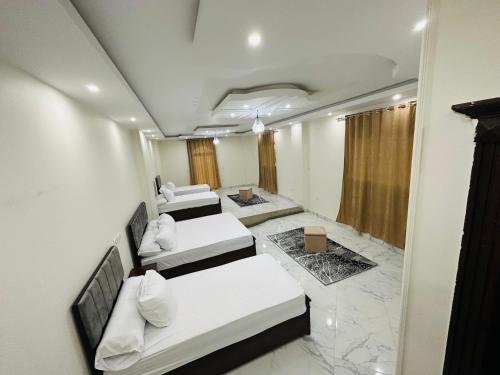 a hotel room with three beds and a room with marble floors at golden mask pyramids view in Cairo