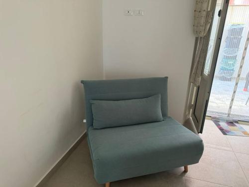 a blue chair with a pillow in a room at Casa Ortensia in Santa Teresa di Riva
