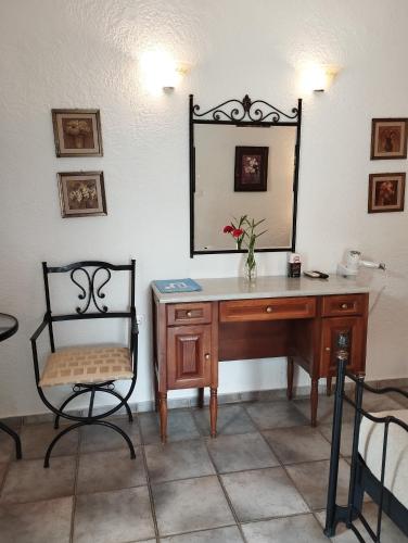 a desk with a chair and a mirror on a wall at Lakki Village in Aegiali