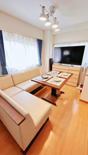 a living room with a couch and a table at 長期滞在 HYGGE HOUSE 駐車無料 JR北柏駅徒歩2分 フルキッチン 洗濯乾燥機 高速Wi-Fi アメニティ完備 上野30分 成田or羽田空港60分 in Kashiwa